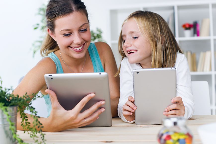 Mutter und Tochter spielen mit Tablets