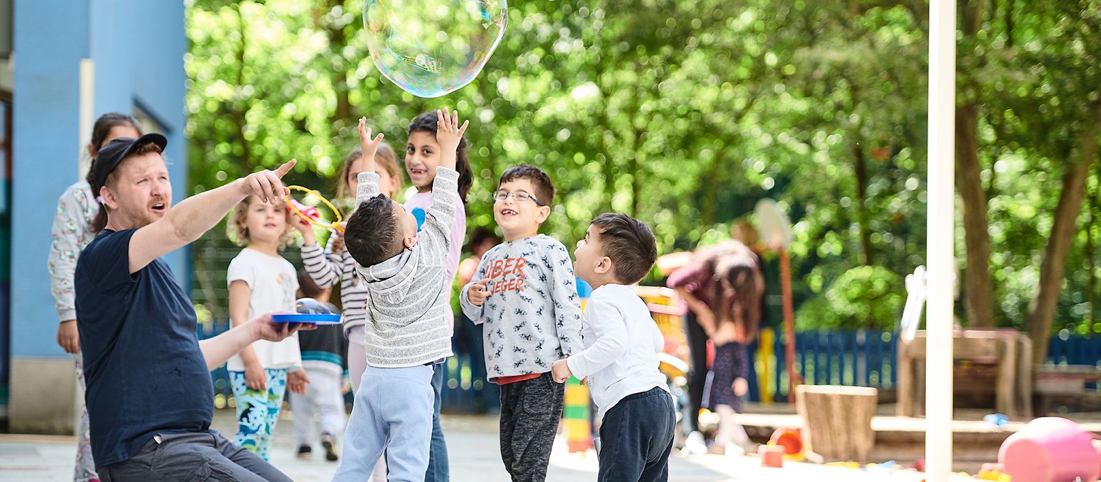 Ein Erzieher betreut eine Gruppe kleiner Kinder