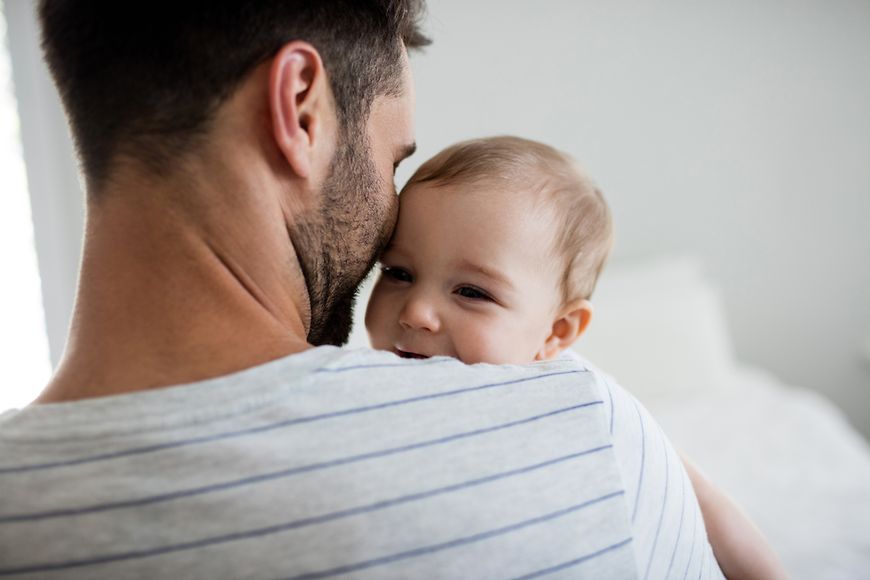 Ein Vater mit seinen zwei Kindern in der Küche, der Vereinbarkeit zwischen Beruf und Familie schafft