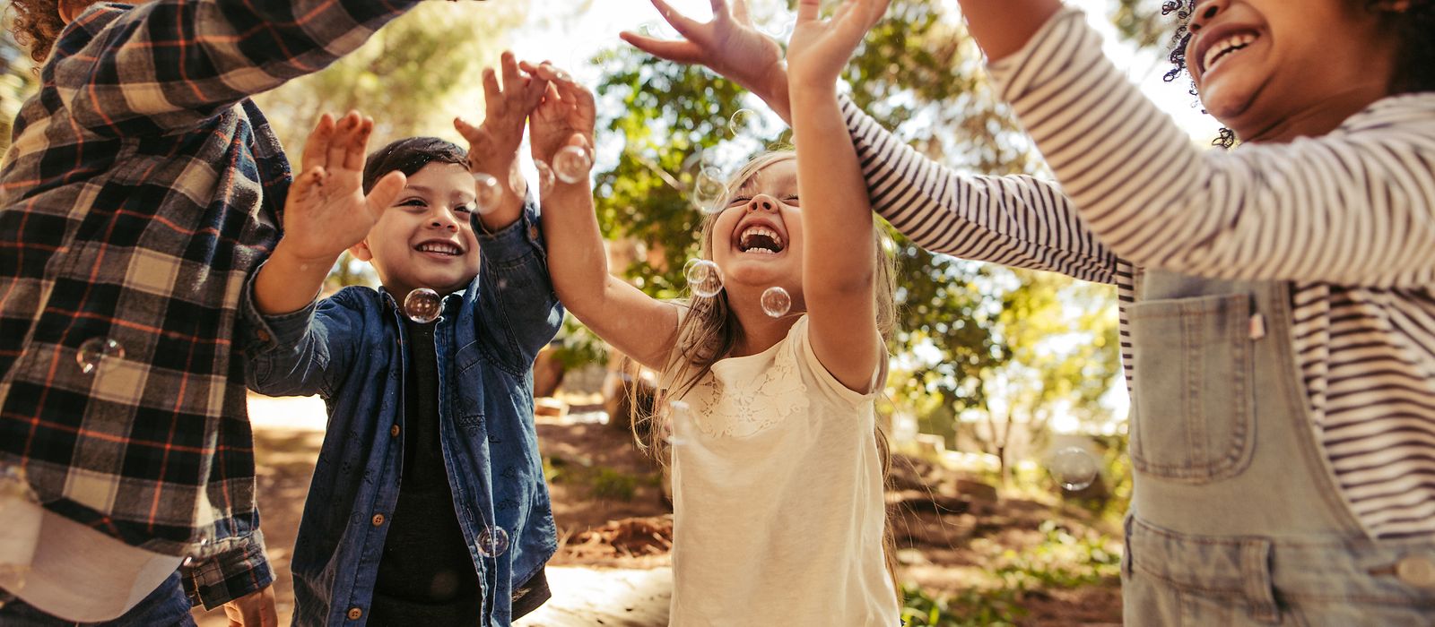 Kinder spielen mit Seifenblasen