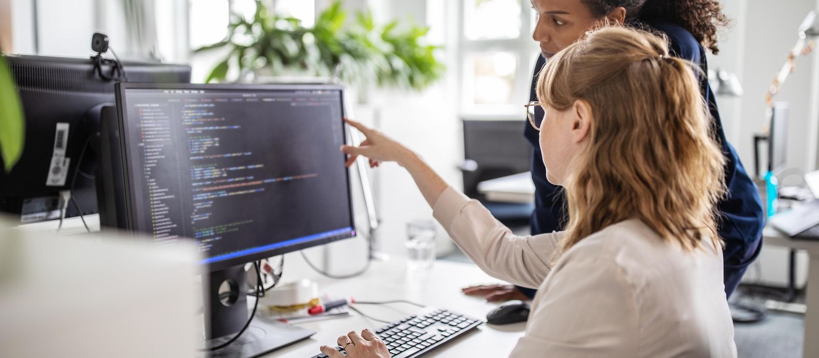 Zwei Geschäftsfrauen, die im Büro am Computer zusammenarbeiten