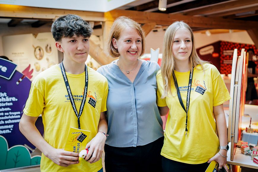 Lisa Paus posiert für ein Foto mit jungen Besucherinnen und Besuchern der Kinderrechte-Ausstellung