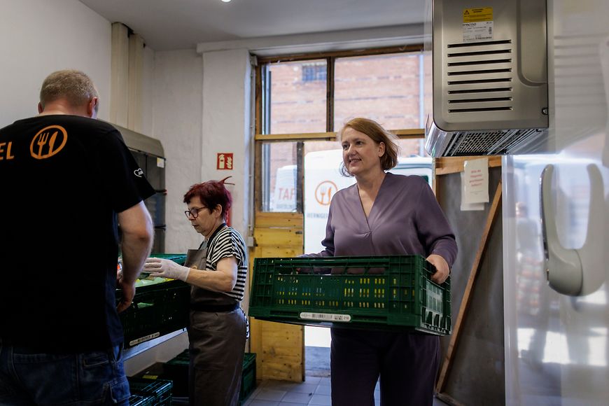 Lisa Paus und weitere Personen stehen in einem Innenhof